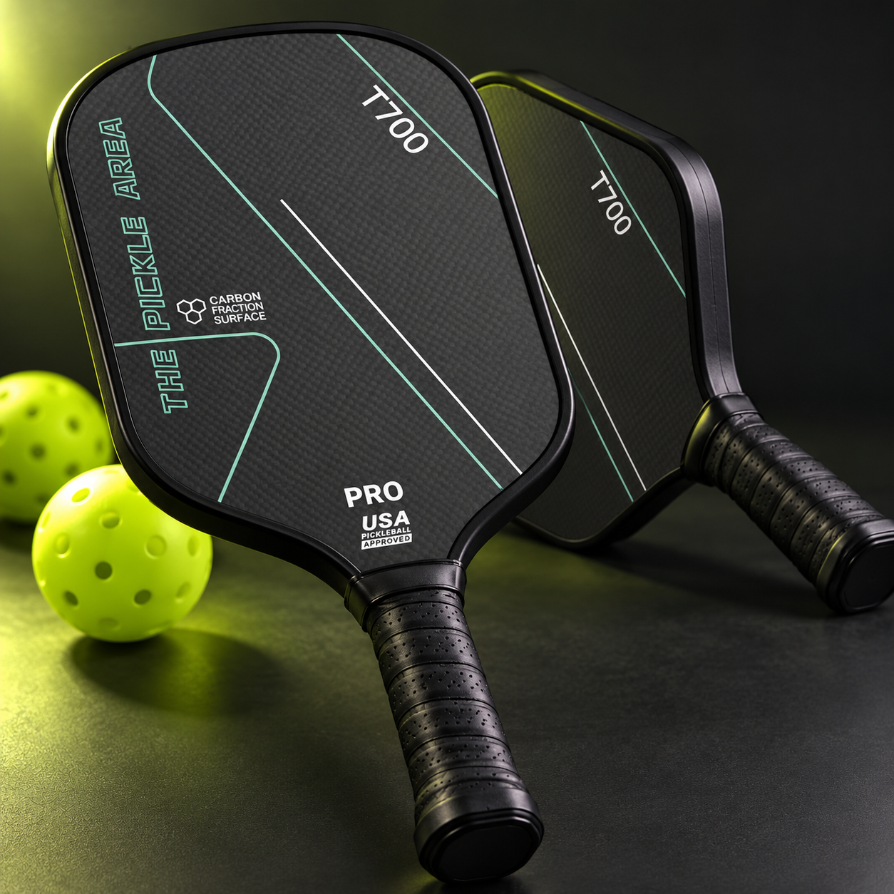 Two charcoal T700 carbon-fibre pickleball paddles with four yellow and lime balls and a black carrying case.
